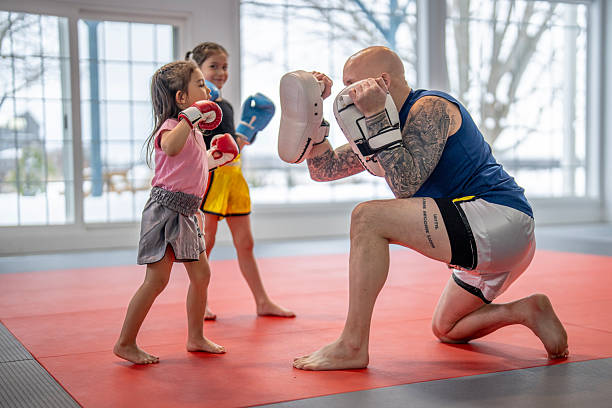 Kids Muay Thai with coach holding pads